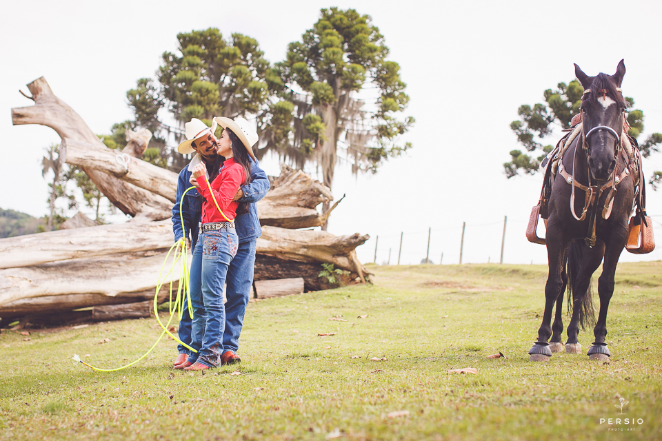casal se olhando fazendo fotos com cavalos na chacara capela das graças em araucaria parana ensaio com os fotografos persio photo art