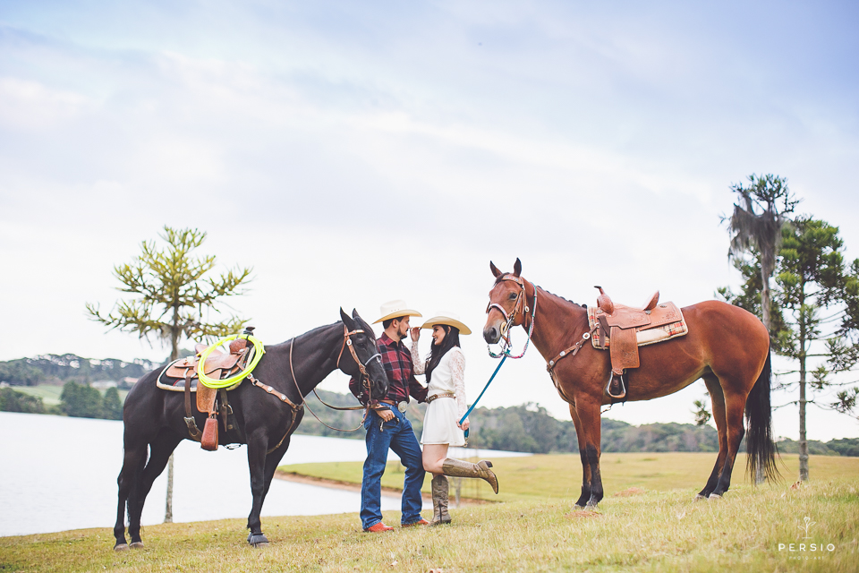 casal se olhando fazendo fotos com cavalos na chacara capela das graças em araucaria parana ensaio com os fotografos persio photo art