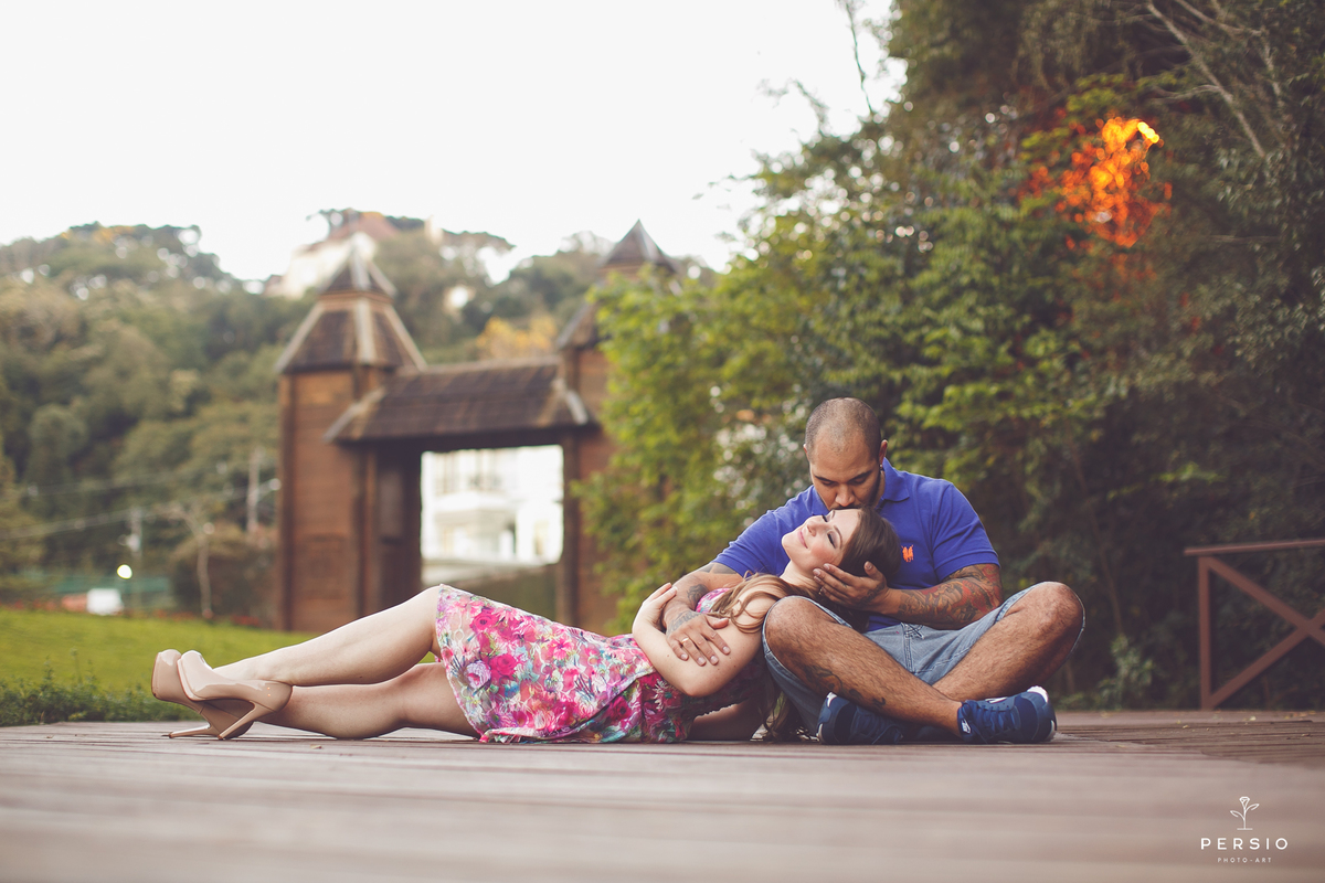 noiva deitada no colo do noivo sorrindo e ganhando um beijo na testa ensaio super romantico no parque tingui memorial ucraniano em curitiba fotos feitas por Raphaela Persio Photo Art