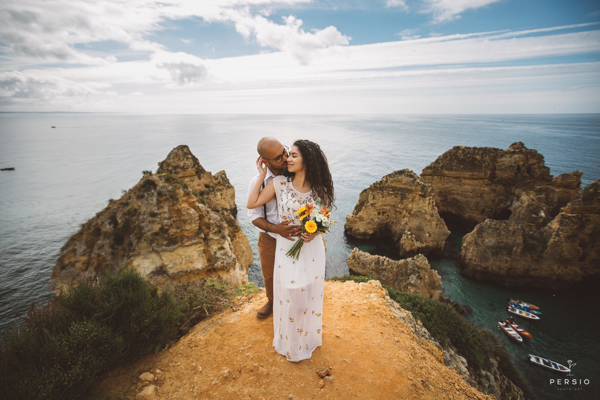 noiva fazendo carinho no noivo céu azul praia linda em Algarve Portugal