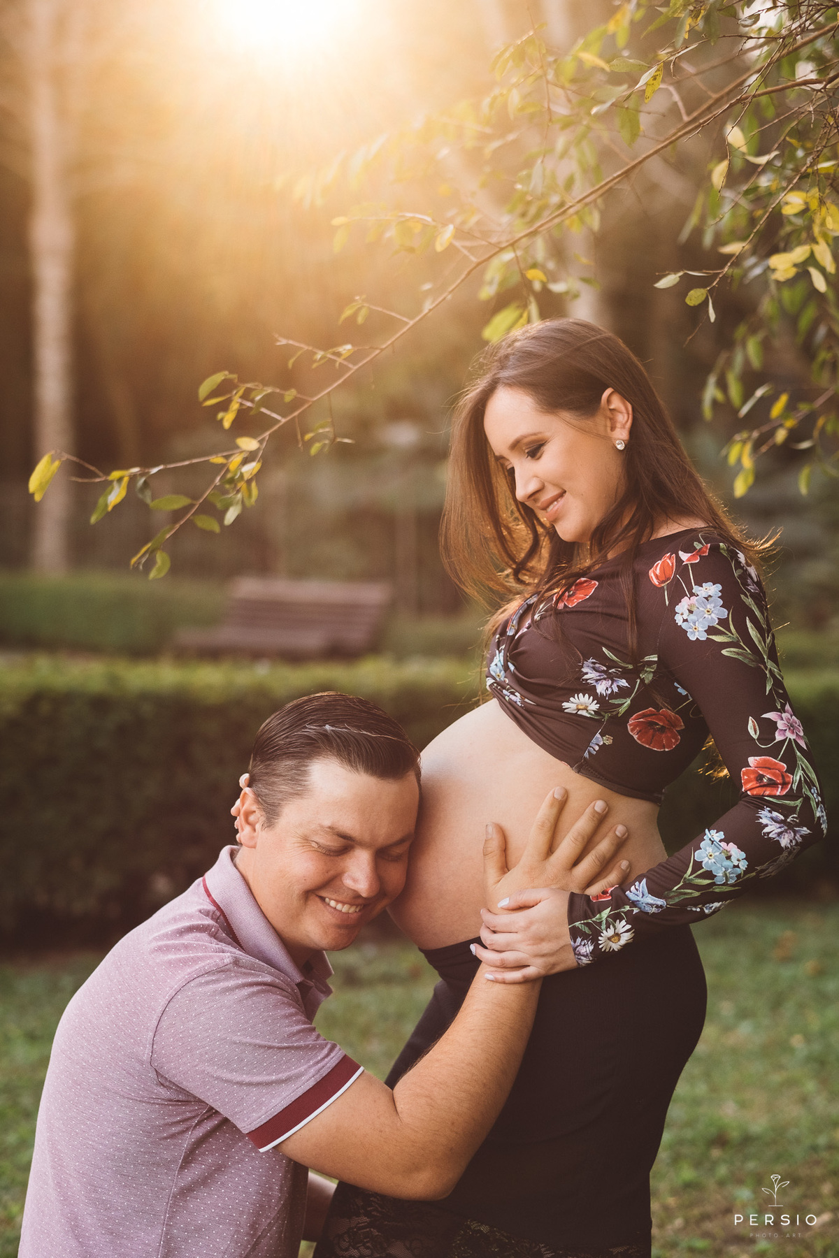 papai ajoelhado abraçando a barriga da gestante