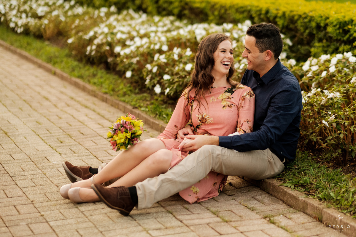 casal de noivos sentados na calçada no jardim do parque tangué