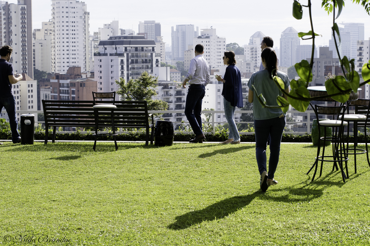 Funcionários da empresa admiram a vista urbana da cidade de São Paulo. 