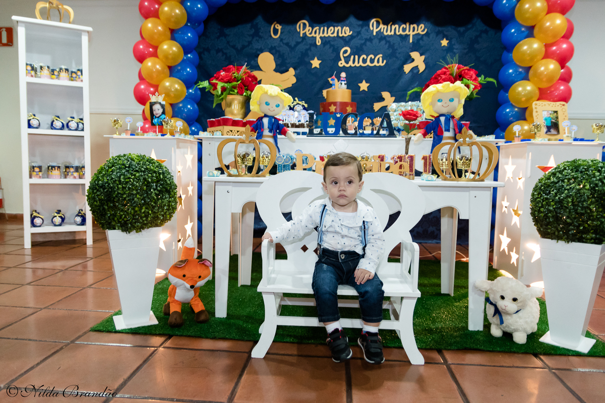 Aniversariante posa para foto na sua festinha de um ano. 