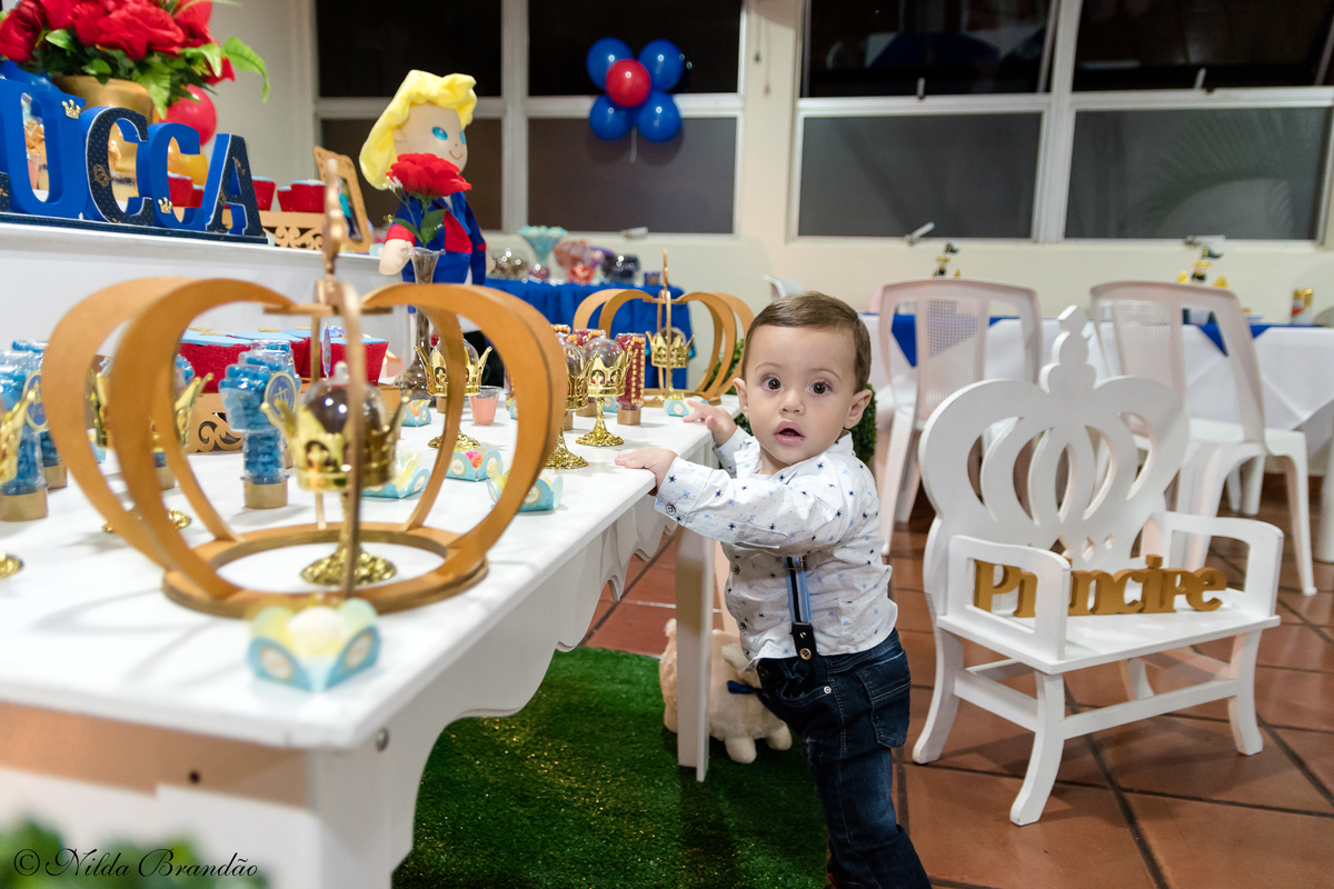 Aniversariante posa para foto na sua festinha de um ano. 