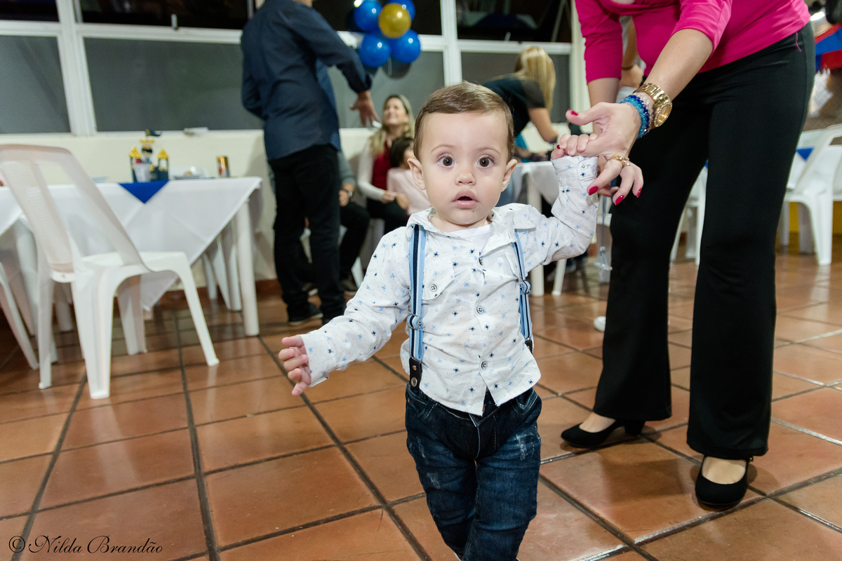 Aniversariante posa para foto na sua festinha de um ano. 