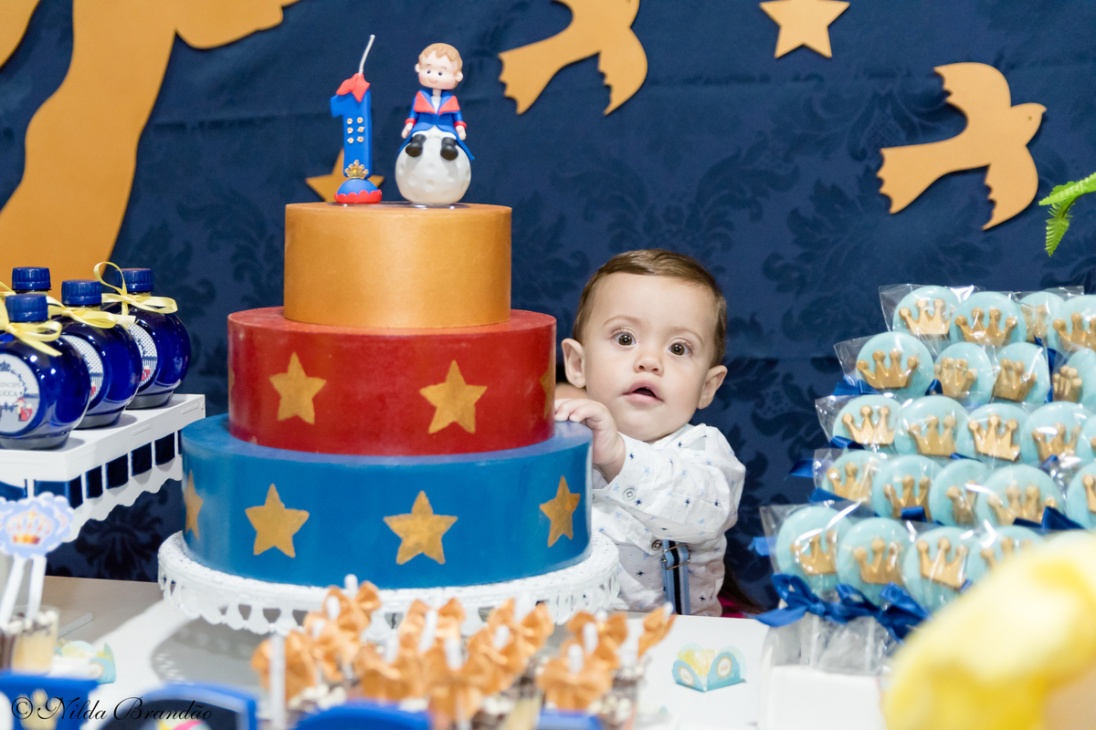 Aniversariante posa para foto na sua festinha de um ano. 