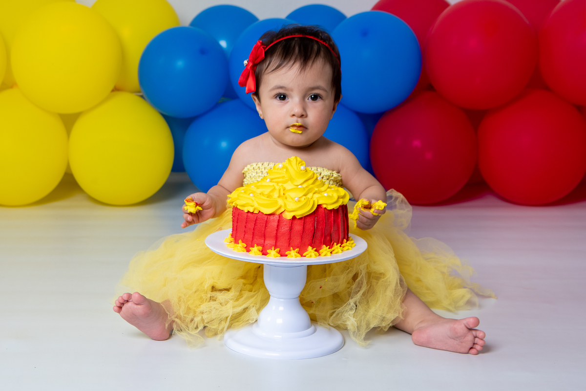 Smash the cake com fotos lúdicas no tema Branca de Neve, primeiro fazemos as fotos lúdicas, depois as fotos do banho de do bolo, enriquecendo ainda mais o primeiro ano da bebê