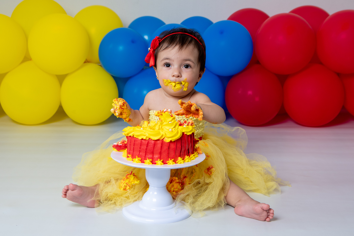Smash the cake com fotos lúdicas no tema Branca de Neve, primeiro fazemos as fotos lúdicas, depois as fotos do banho de do bolo, enriquecendo ainda mais o primeiro ano da bebê