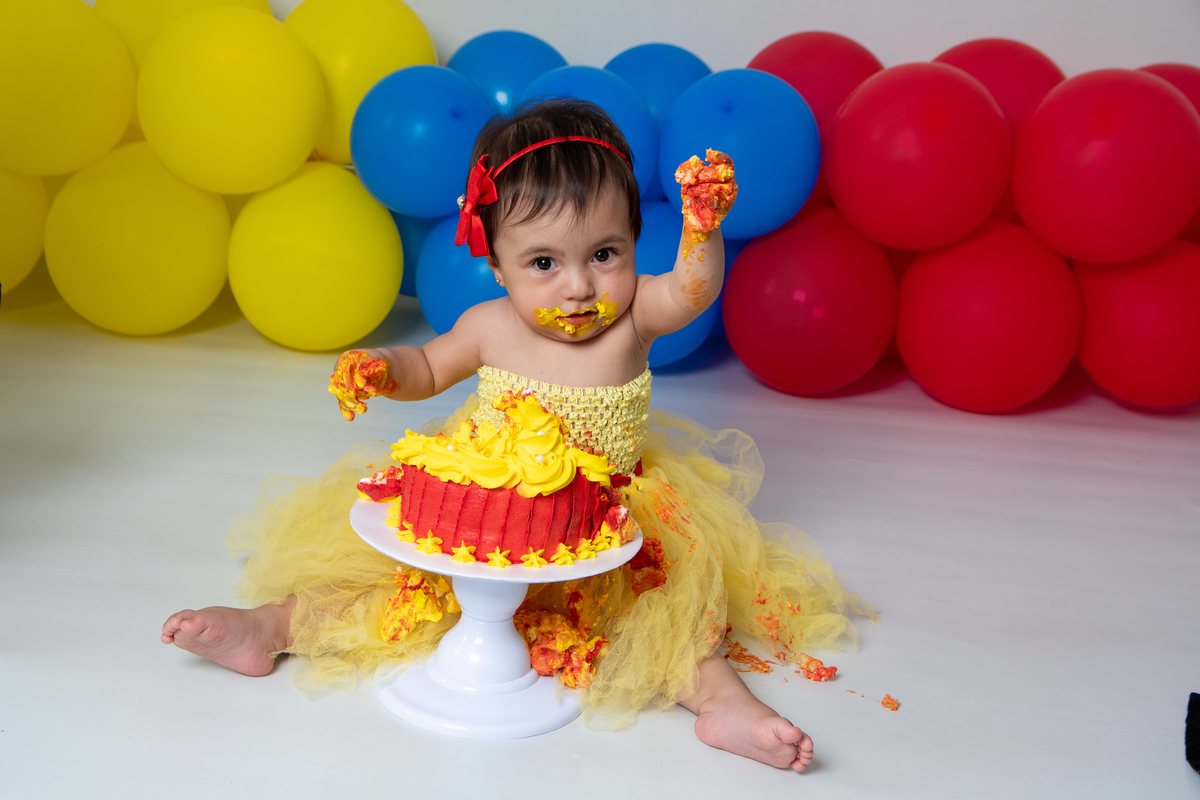 Smash the cake com fotos lúdicas no tema Branca de Neve, primeiro fazemos as fotos lúdicas, depois as fotos do banho de do bolo, enriquecendo ainda mais o primeiro ano da bebê
