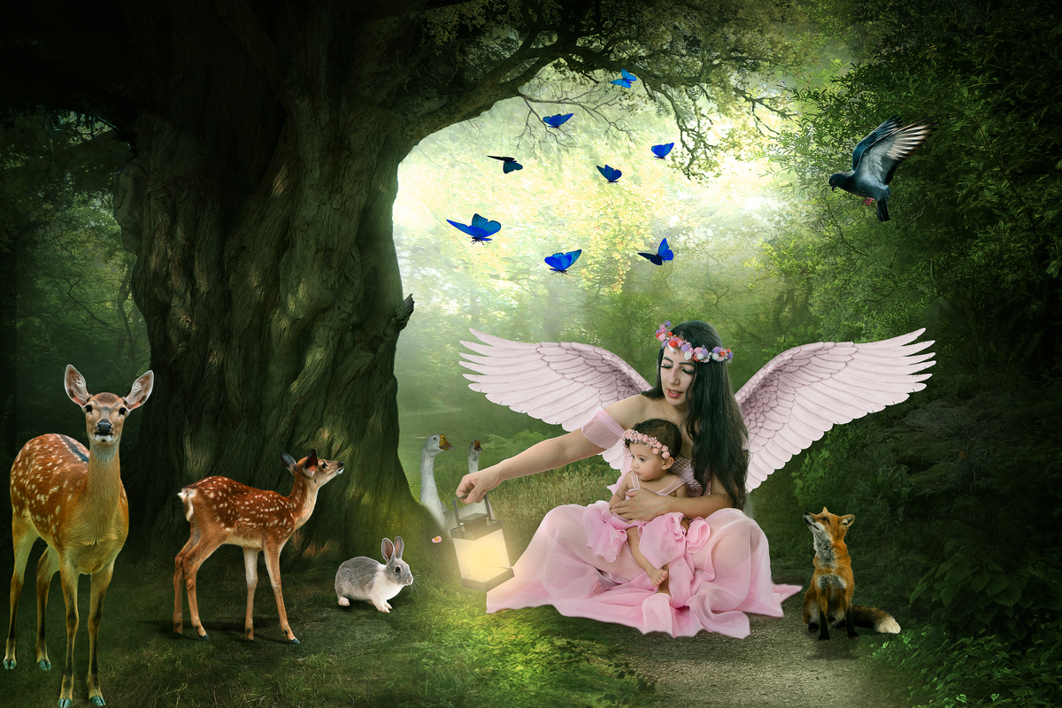 Ensaio fotográfico lúdico com tema Jardim encantado, mãe segurando a filha com asas de anjo 