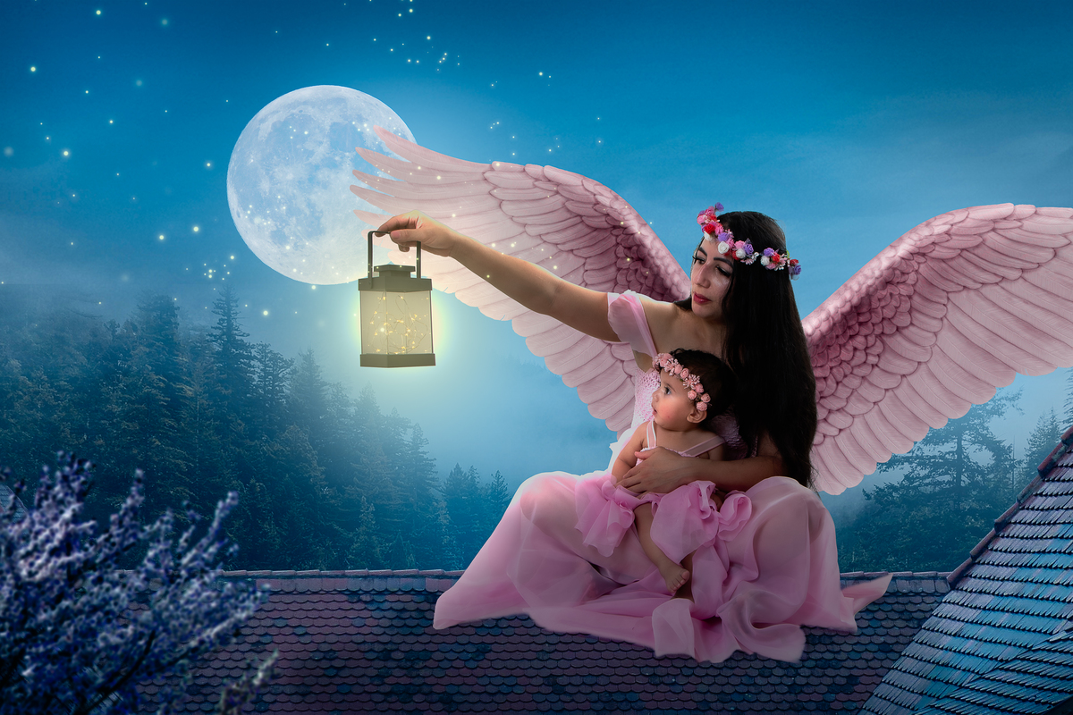 Ensaio fotográfico lúdico com tema Jardim encantado, mãe segurando a filha com asas de anjo 