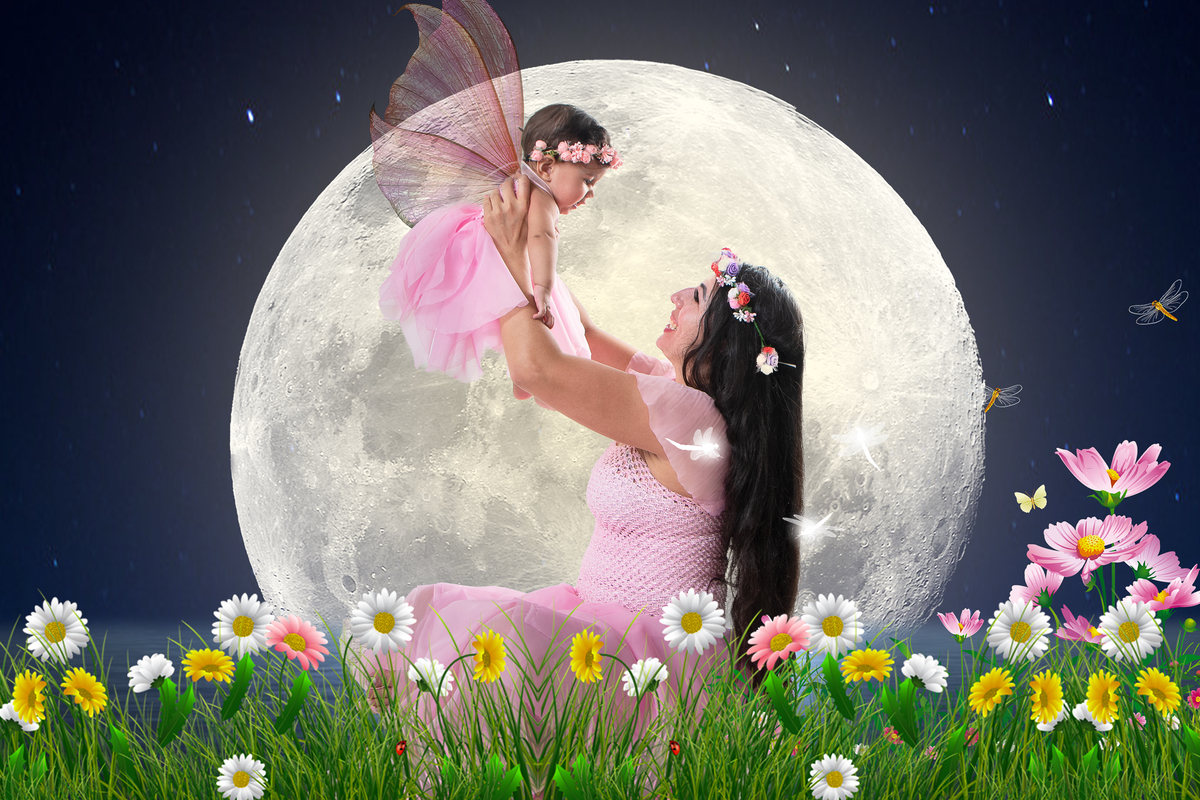 Ensaio fotográfico lúdico com tema Jardim encantado, mãe segurando a filha com asas de fada