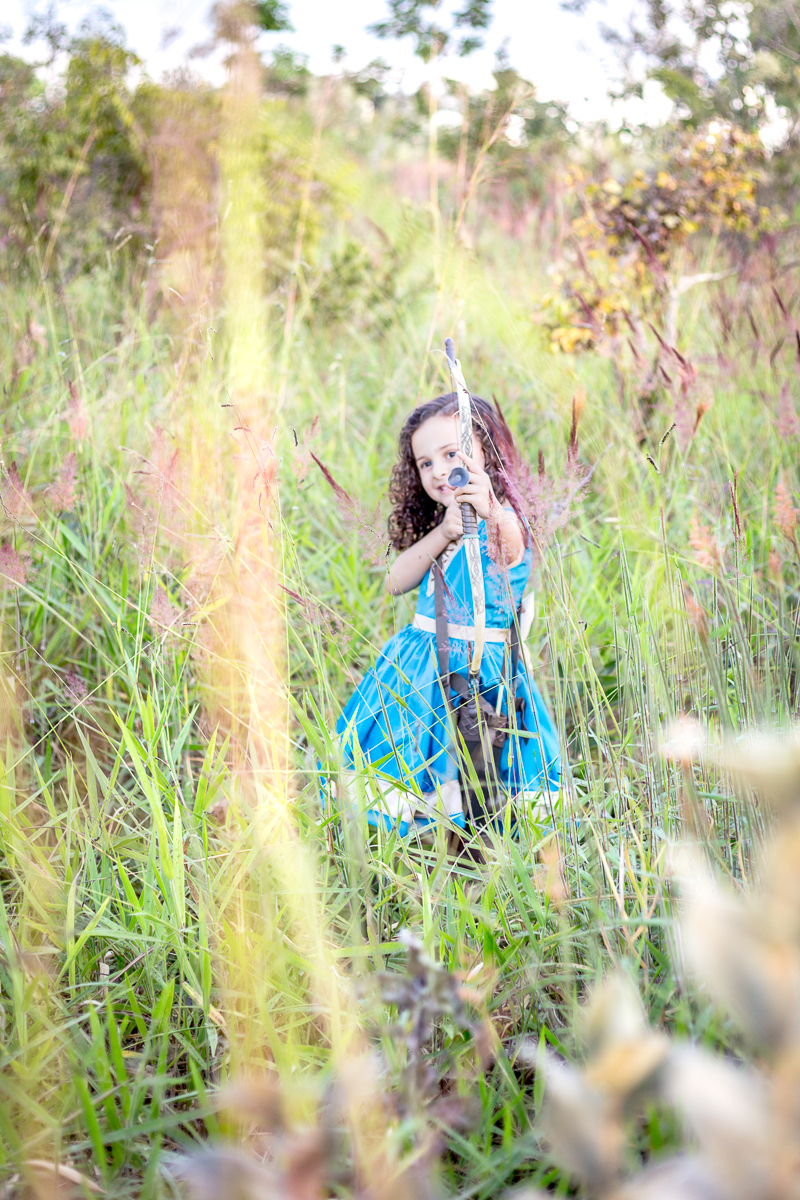 Ensaio infantil Valente Merida nossa filha Cecília arco e flecha diversão vestido azul