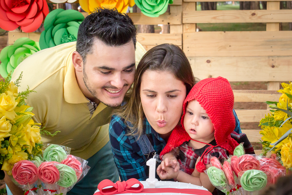Hora de assoprar a velhinha família junta cantando parabéns pai e mãe com a bebê no colo