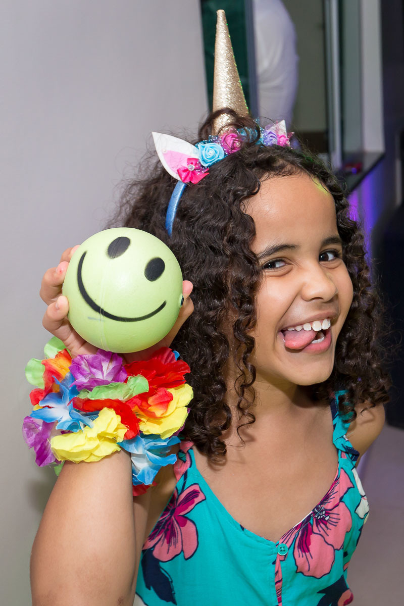 criança cacheada com língua de fora