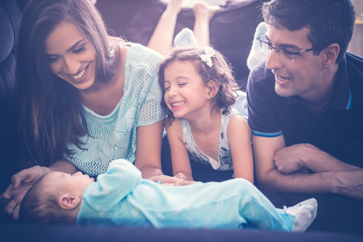 Família vendo o bebê no sofá