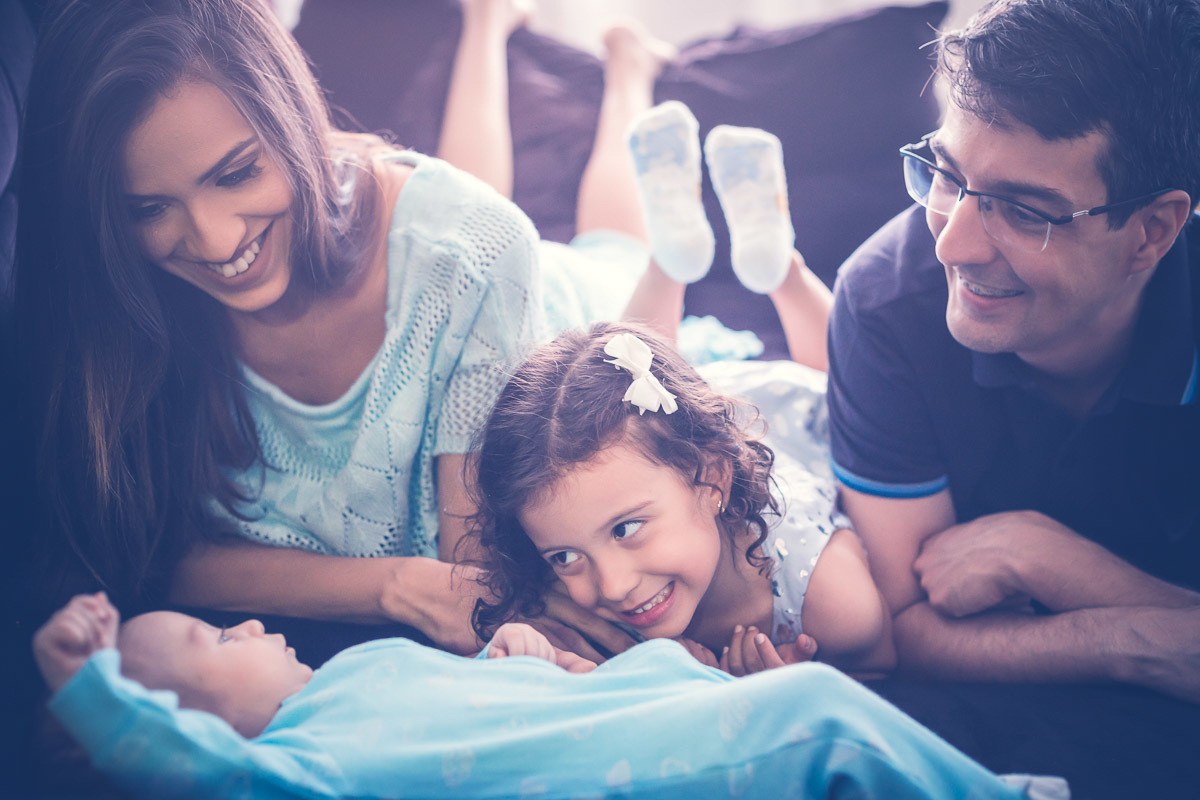 Família brincando com o bebê no sofá