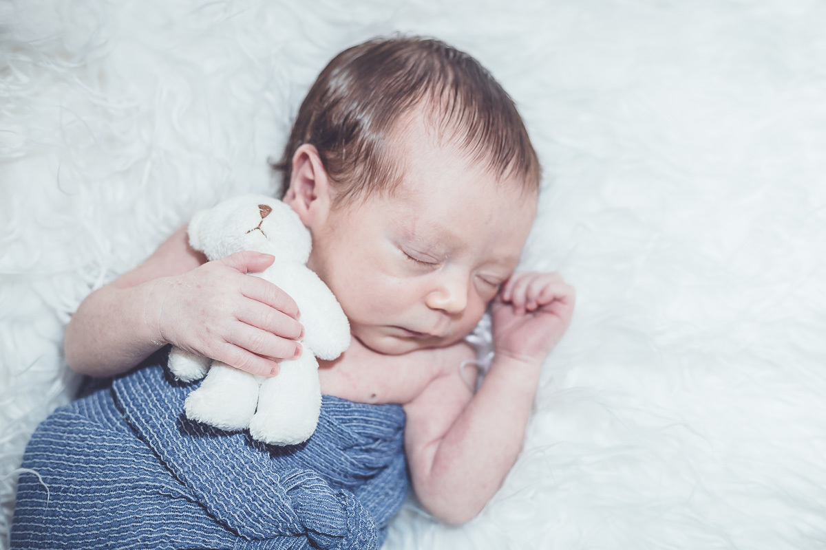 bebê abraçado no ursinho