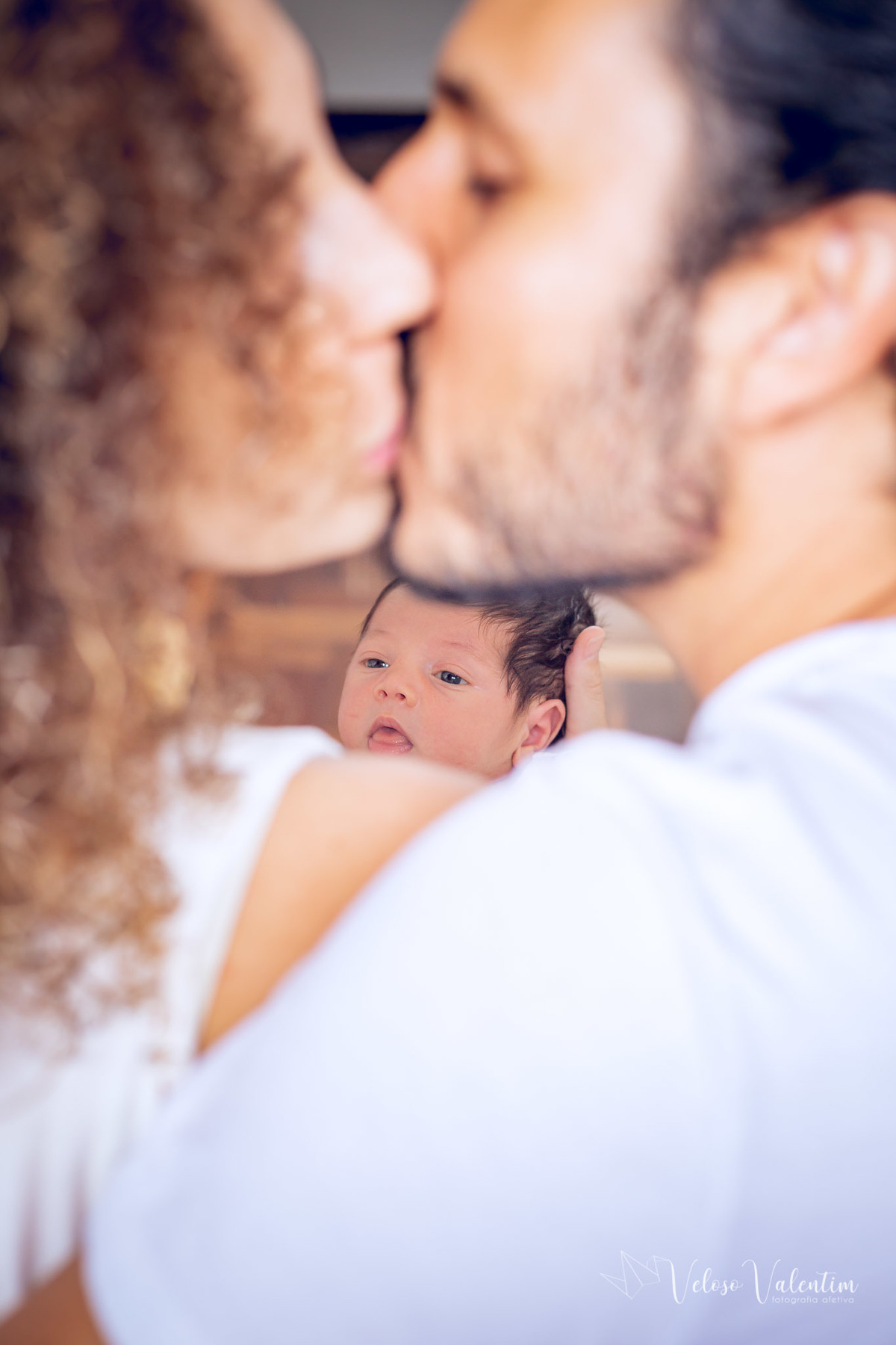 beijo dos pais e bebê no meio