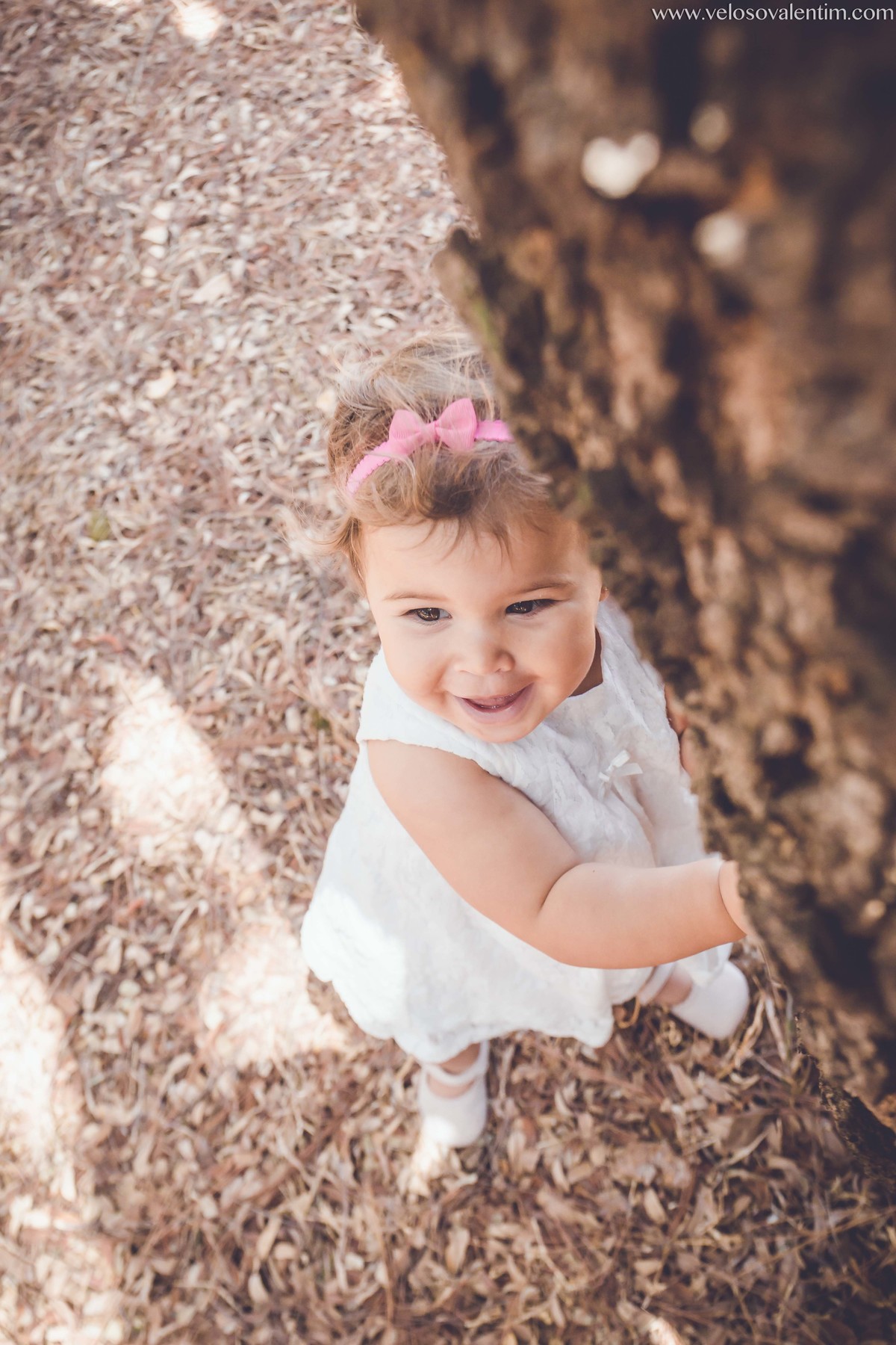 ensaio infantil ao ar livre bebê encostada em tronco de árvore Brasília DF