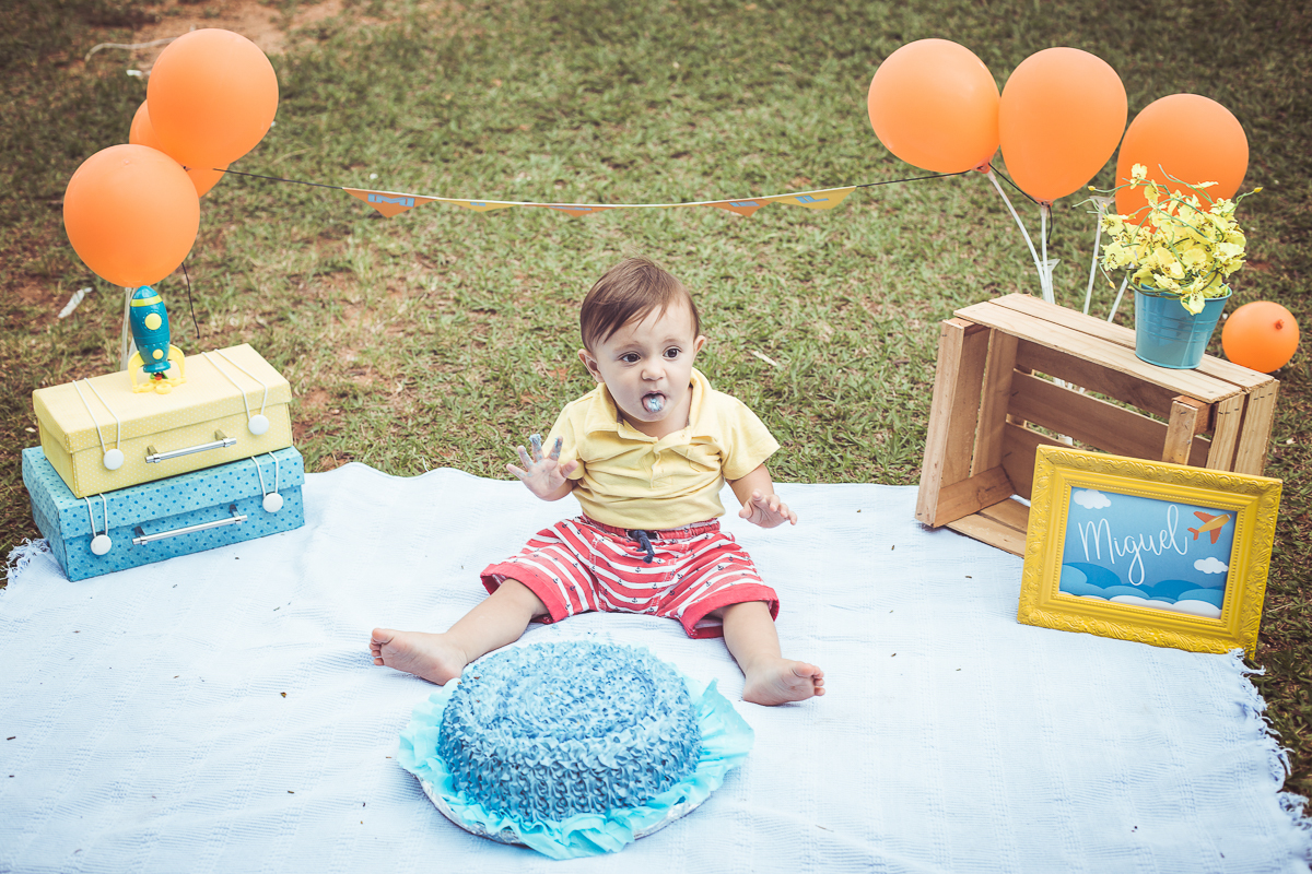 ensaio smash the cake tema foguete primeiro aninho parque da cidade família laranja e azul banho menino  Brasília DF veloso valentim book família fotografia bolo azul