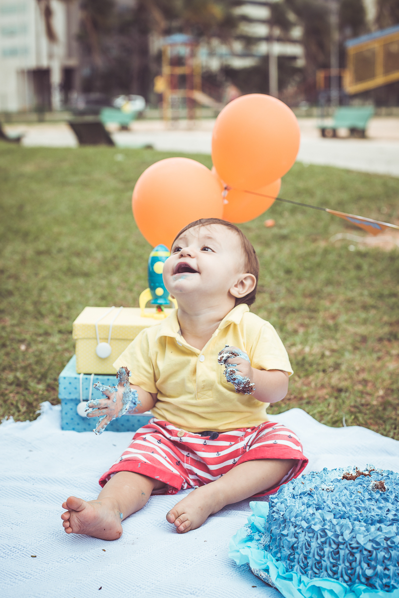 ensaio smash the cake tema foguete primeiro aninho parque da cidade família laranja e azul banho menino  Brasília DF veloso valentim book família fotografia bebê rindo