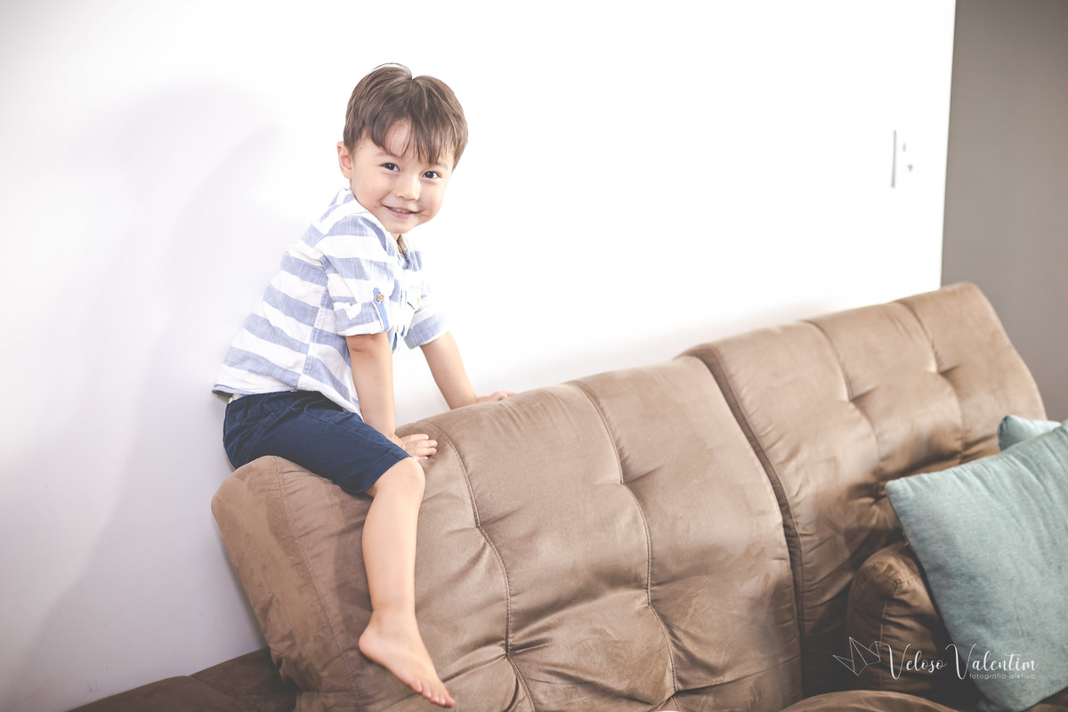 ensaio acompanhamento do primeiro ano do bebê Laura 3 meses em casa com a família ensaio lifestyle cotidiano Brasília DF Veloso Valentim fotografia afetiva irmão mais velho no sofá criança travessa