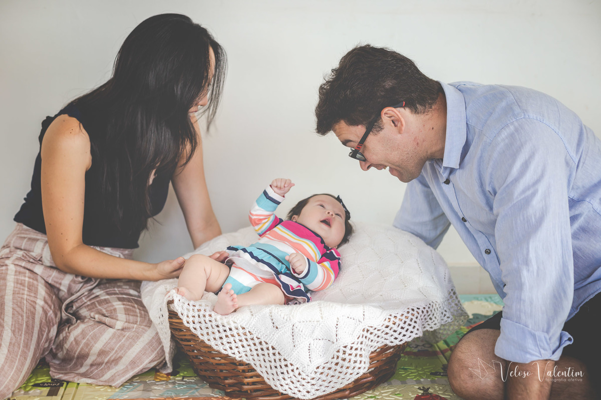 ensaio acompanhamento do primeiro ano do bebê Laura 3 meses em casa com a família ensaio lifestyle cotidiano Brasília DF Veloso Valentim fotografia afetiva família oriental pai e mãe olham a bebê deitada