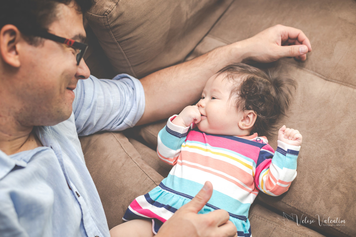 ensaio acompanhamento do primeiro ano do bebê Laura 3 meses em casa com a família ensaio lifestyle cotidiano Brasília DF Veloso Valentim fotografia afetiva família oriental pai olha a bebê deitada e sorri