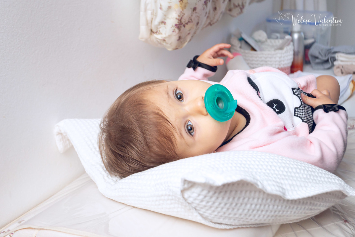 ensaio acompanhamento do primeiro ano do bebê Aurora 12 meses em casa com a família ao ar livre aprendendo a andar primeiros passos Brasília DF Veloso Valentim fotografia afetiva bebê de chupeta deitada no trocador
