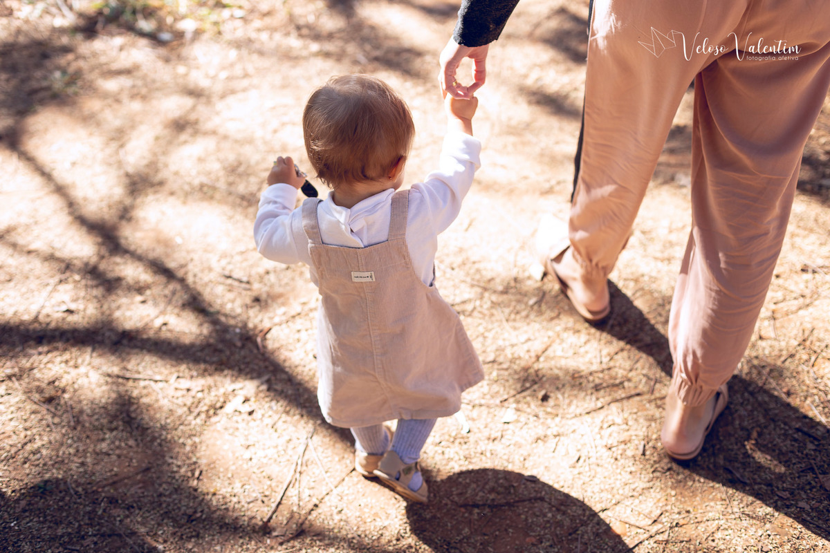 ensaio acompanhamento do primeiro ano do bebê Aurora 12 meses em casa com a família ao ar livre aprendendo a andar primeiros passos Brasília DF Veloso Valentim fotografia afetiva bebê andando na grama com a mãe