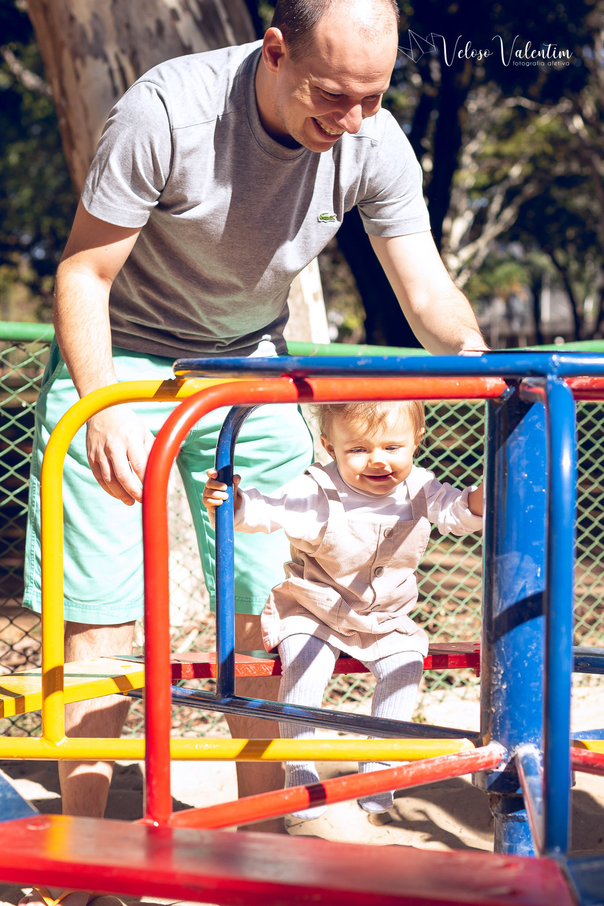 ensaio acompanhamento do primeiro ano do bebê Aurora 12 meses em casa com a família ao ar livre aprendendo a andar primeiros passos Brasília DF Veloso Valentim fotografia afetiva bebê no gira gira do parquinho
