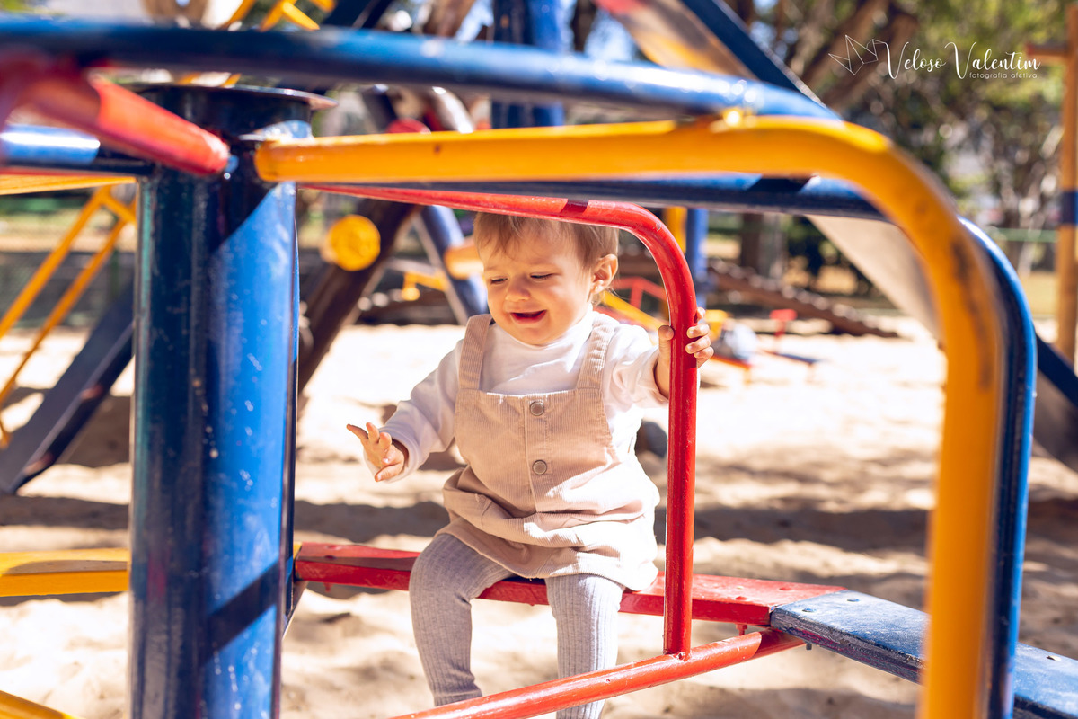 ensaio acompanhamento do primeiro ano do bebê Aurora 12 meses em casa com a família ao ar livre aprendendo a andar primeiros passos Brasília DF Veloso Valentim fotografia afetiva bebê no balanço do parquinho com o pai