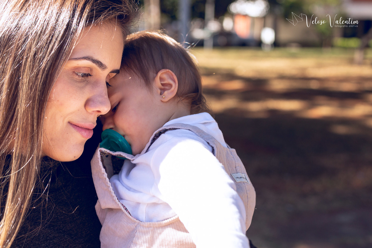 ensaio acompanhamento do primeiro ano do bebê Aurora 12 meses em casa com a família ao ar livre aprendendo a andar primeiros passos Brasília DF Veloso Valentim fotografia afetiva bebê no colinho da mãe aconchego
