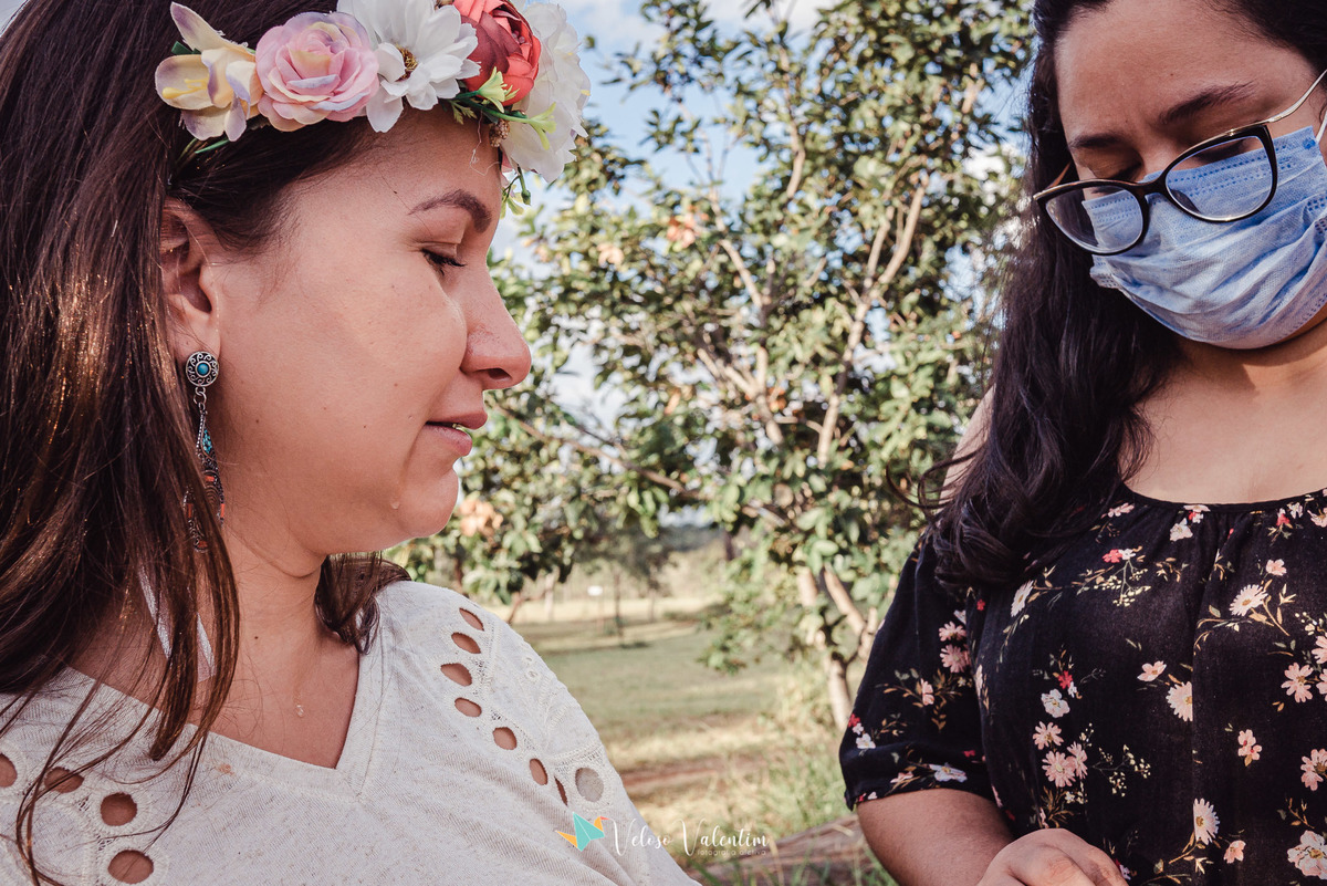 mulher com coroa de flores e mulher de óculos e máscara