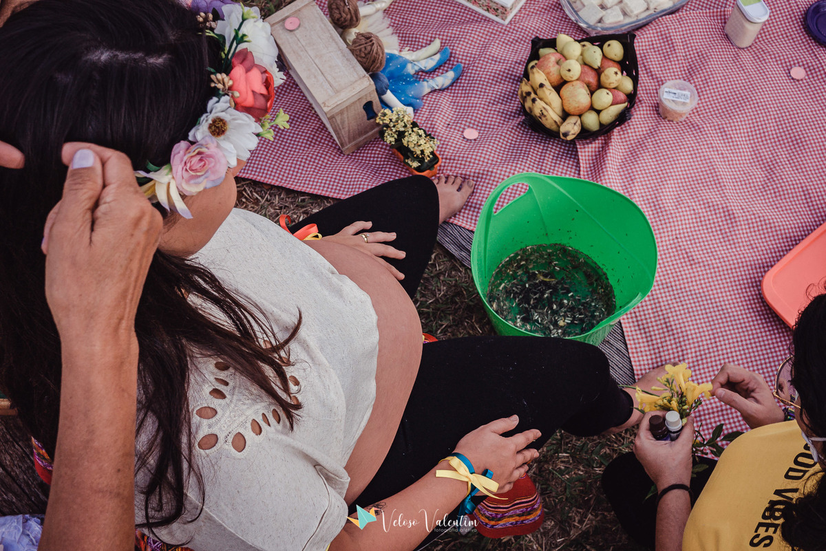 escalda pés com ervas numa bacia verde e toalha de picnic