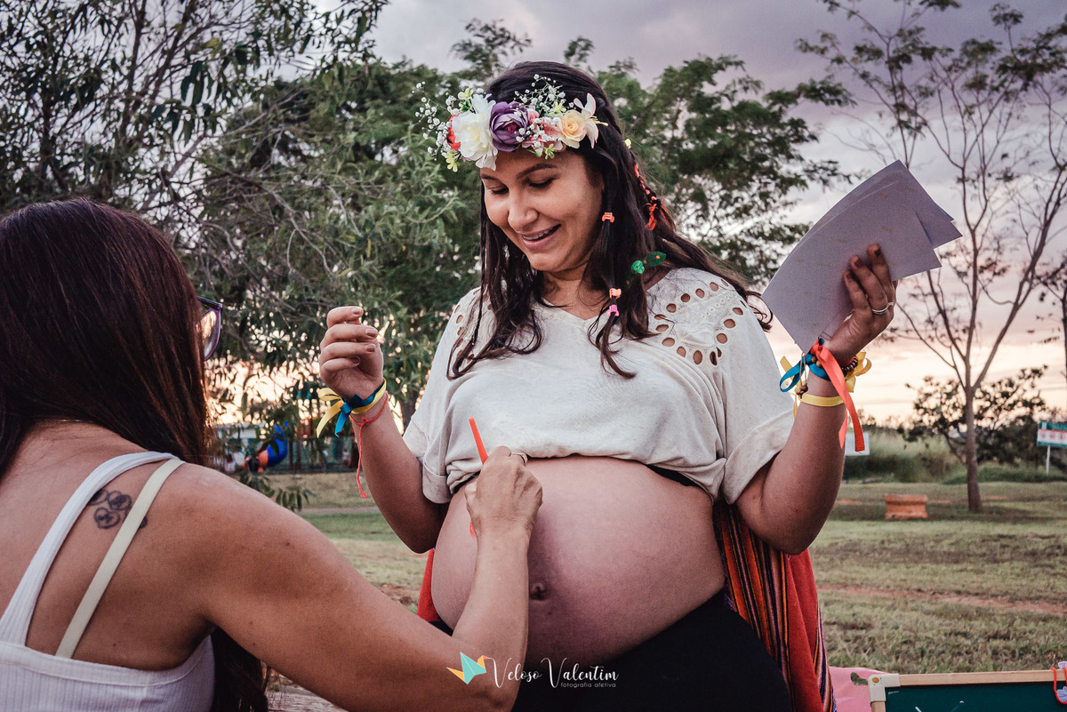 mulher desenha na barriga da gestante