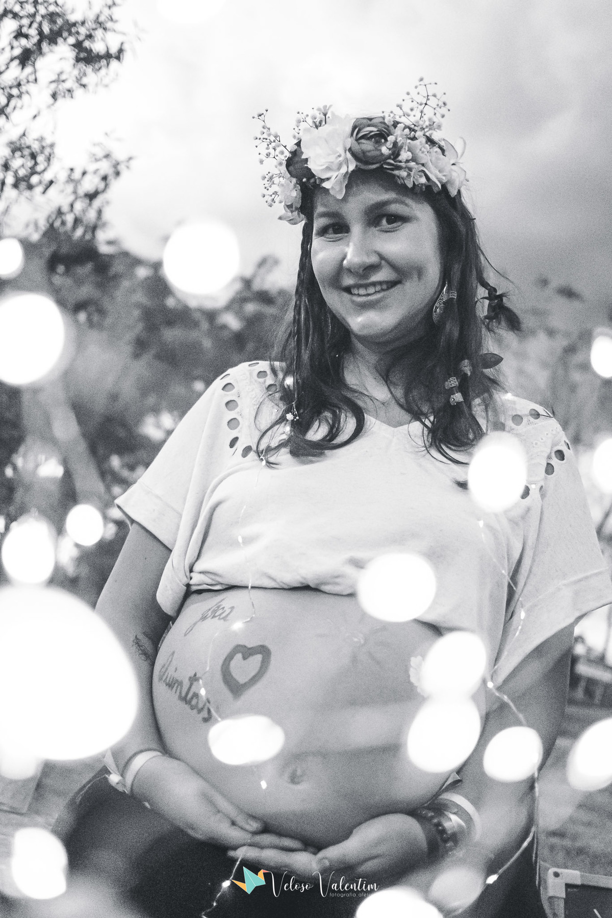 foto preta e branca de mulher gestante com pintura de barriga