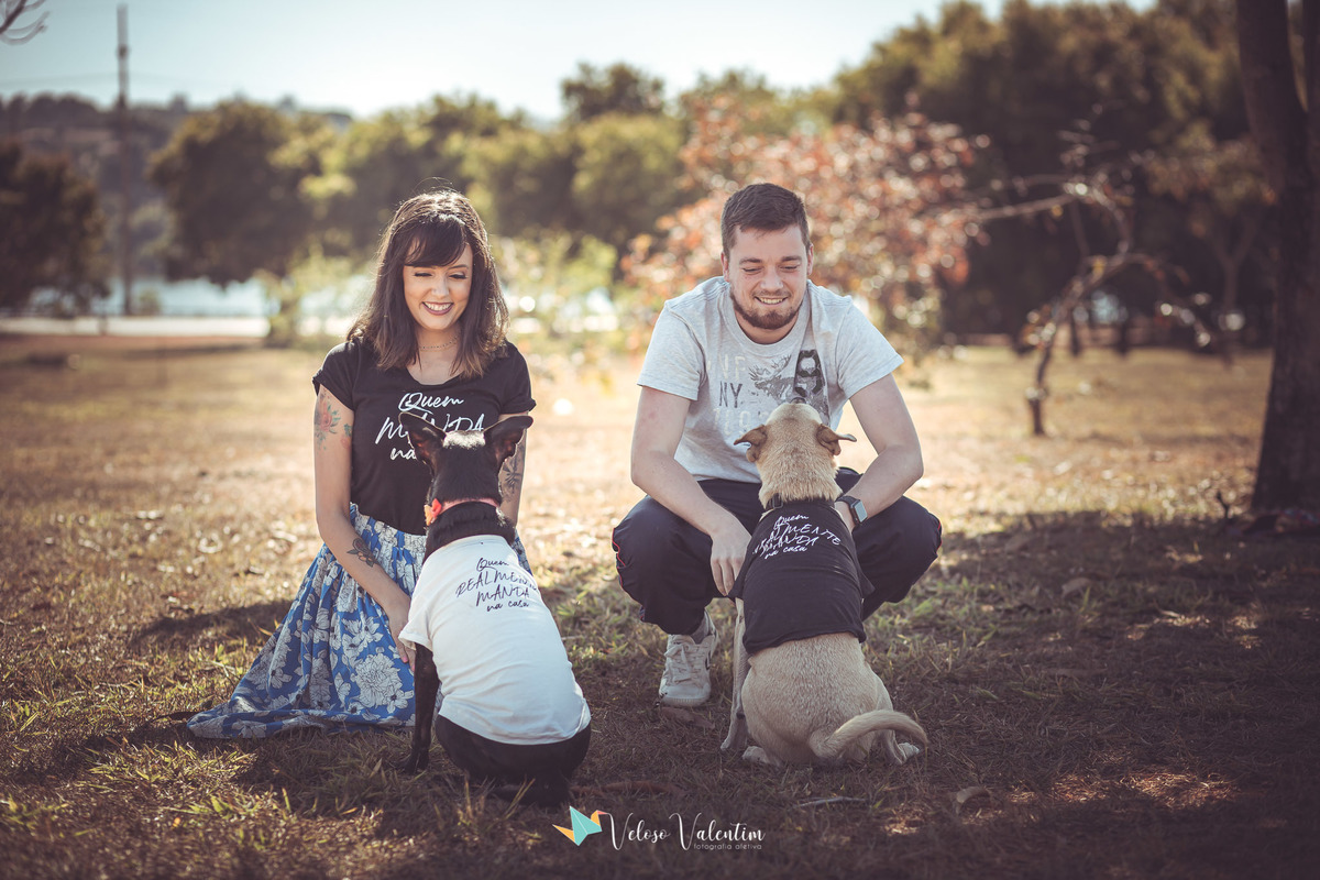 casal agachado olhando para 2 cachorros