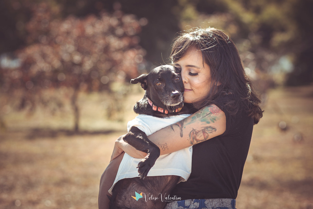 mulher tatuada com cachorro no colo