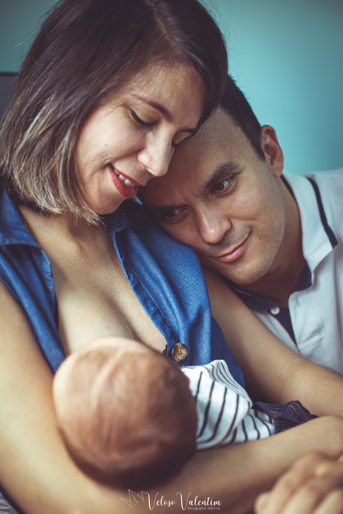 mãe amamentando o filho ao lado do pai