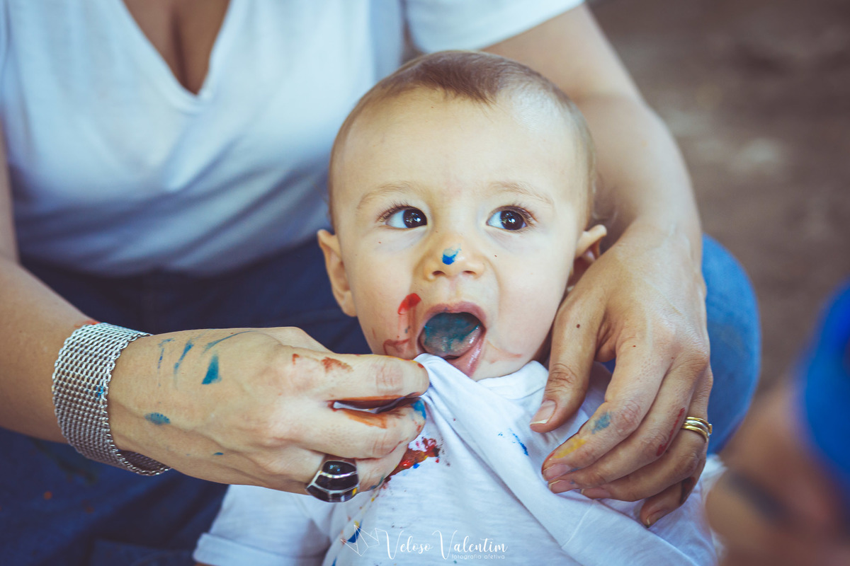 mãe limpando o bebê com tinta