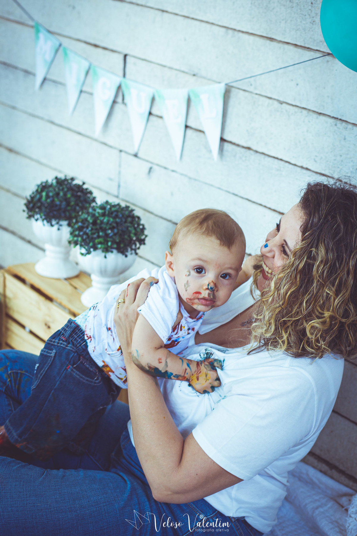 bebê todo sujo de tinta no colo da mãe