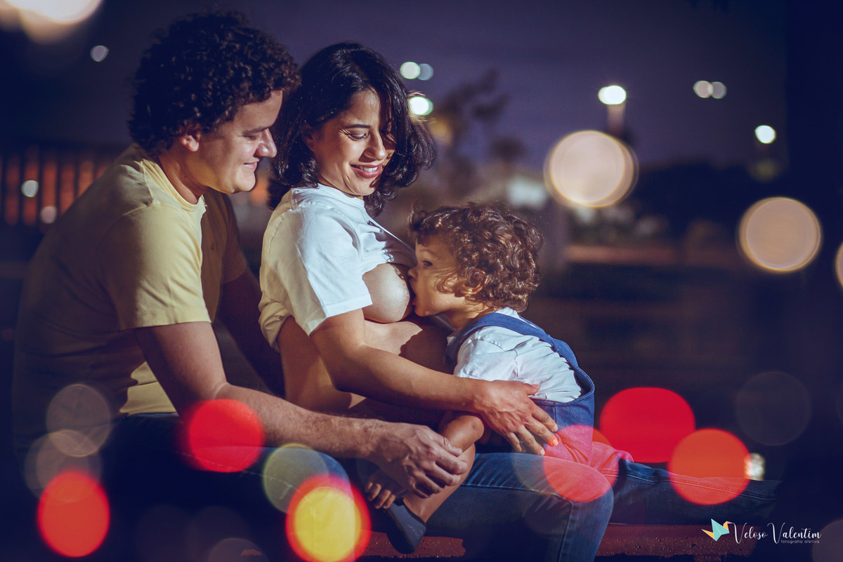 família sentada com bebê mamando