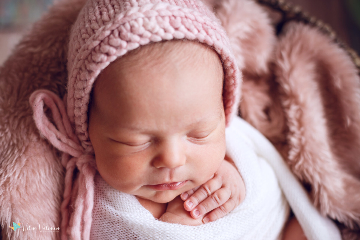 close no rosto bebê deitada dormindo com touca rosa ensaio newborn em casa Brasília