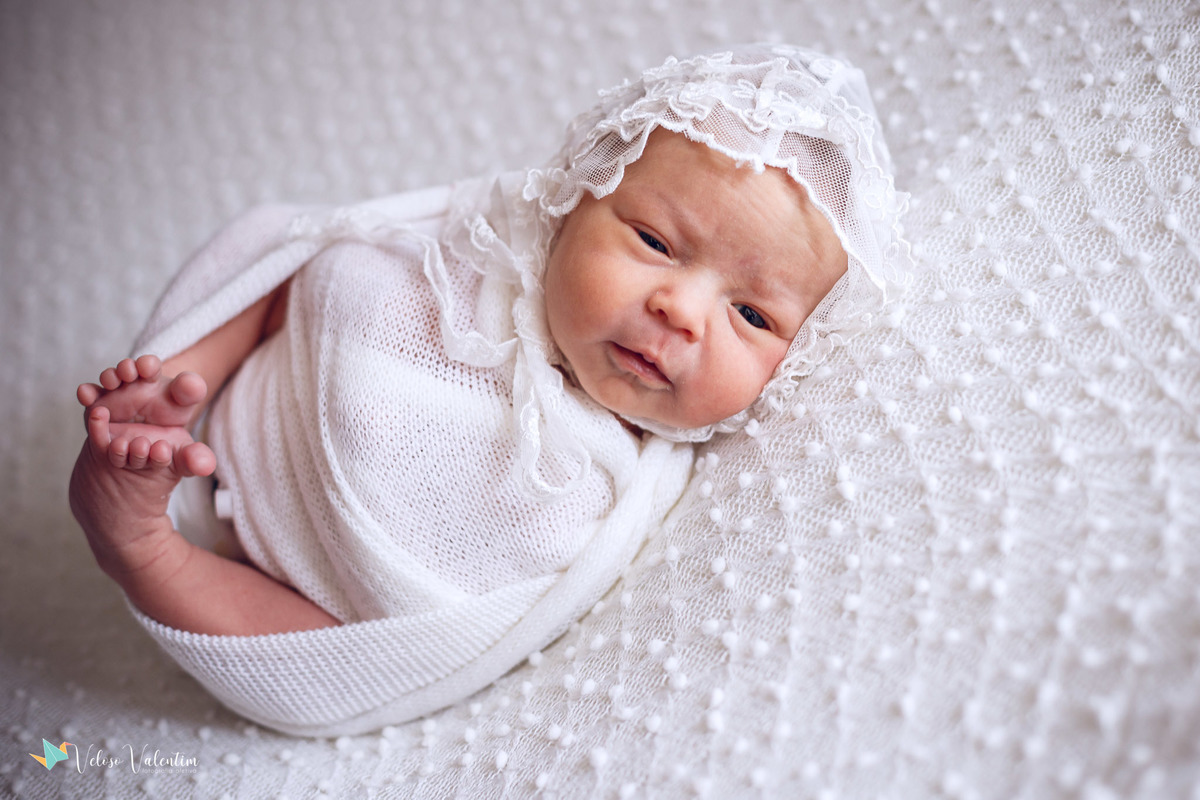 bebê deitada de touquinha branca ensaio newborn em casa Brasília