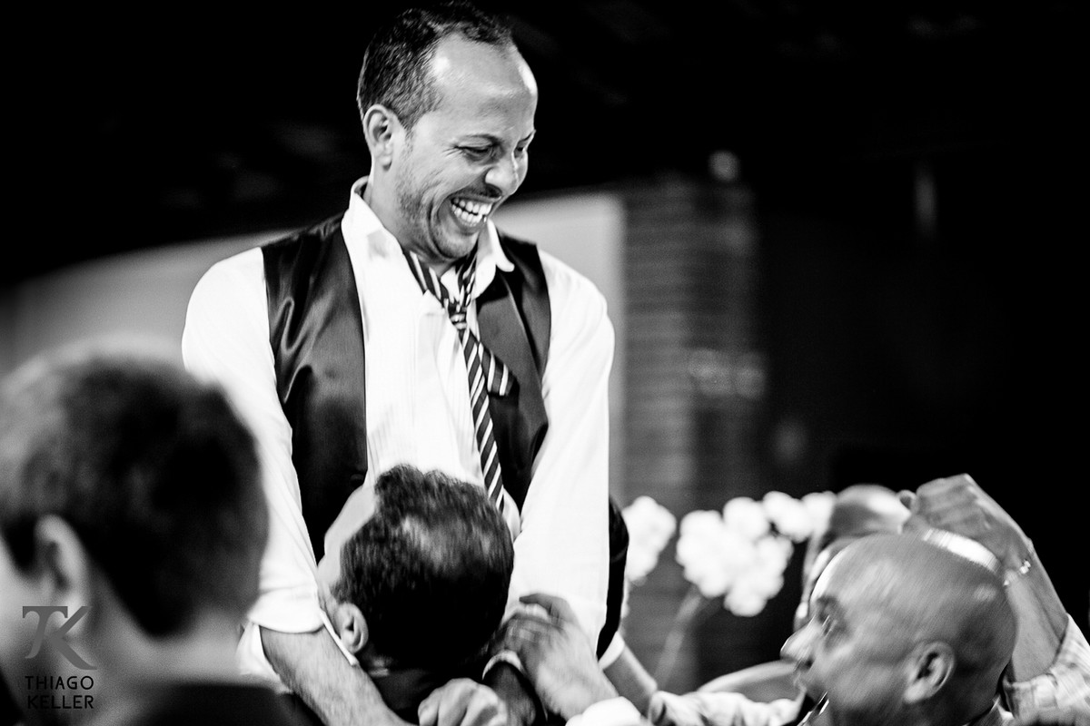 Fotografia de casamento por Thiago Keller na cidade de Paracatu, Minas Gerais. A alegria do noivo compartilhada com seus amigos.