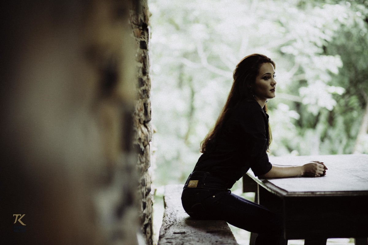 Sessão Fotográfica com Ana Lima, realizado em Minas Gerais. Foto da modelo sentada na mesa. Observação.