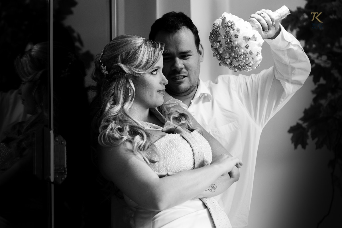 Foto de casamento em Minas Gerais. Pós-wedding com noiva e noivo em cena divertida com o buquê e gravata. Foto P